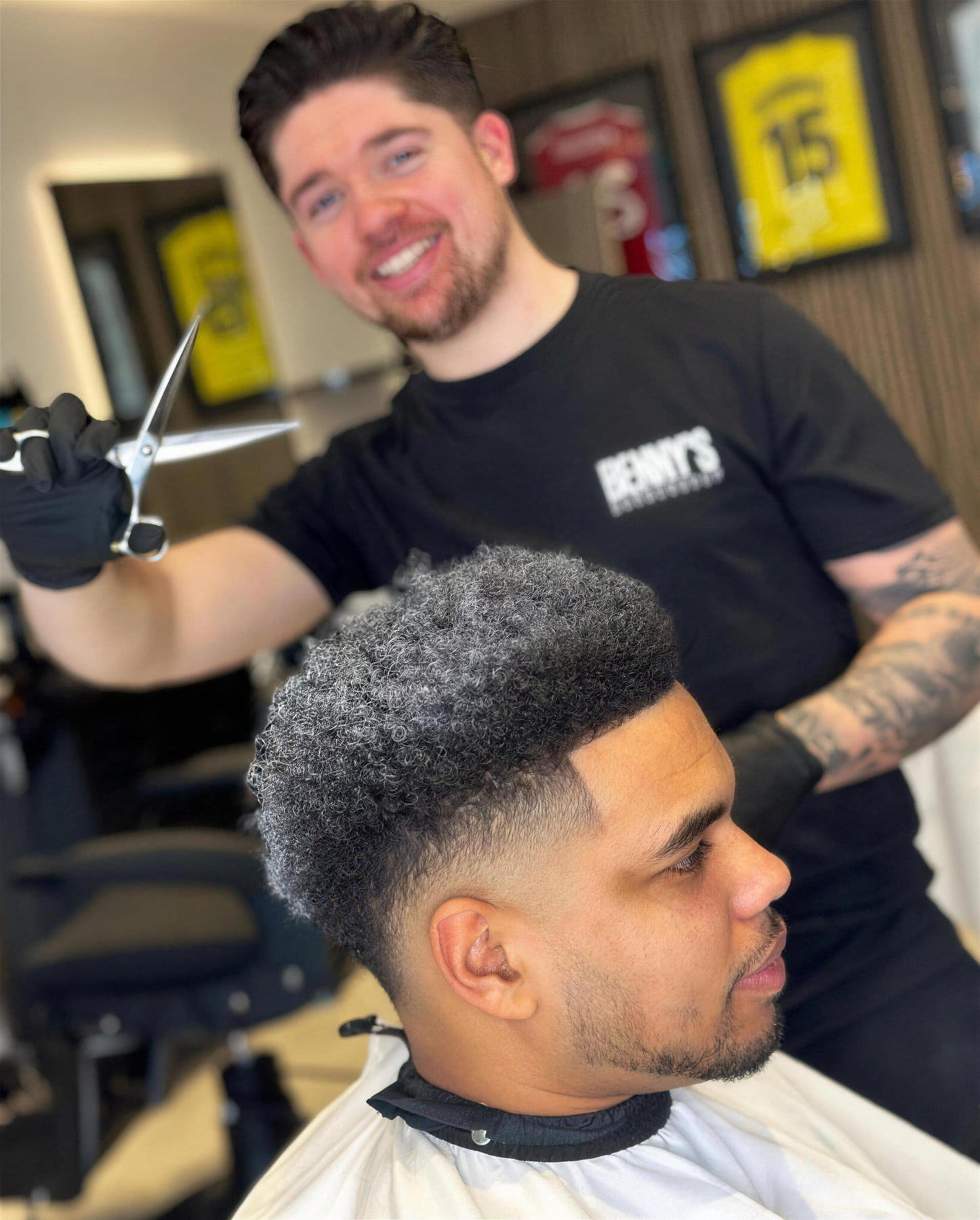 A skin fade with curls on top, cut at Benny's Barbershop
