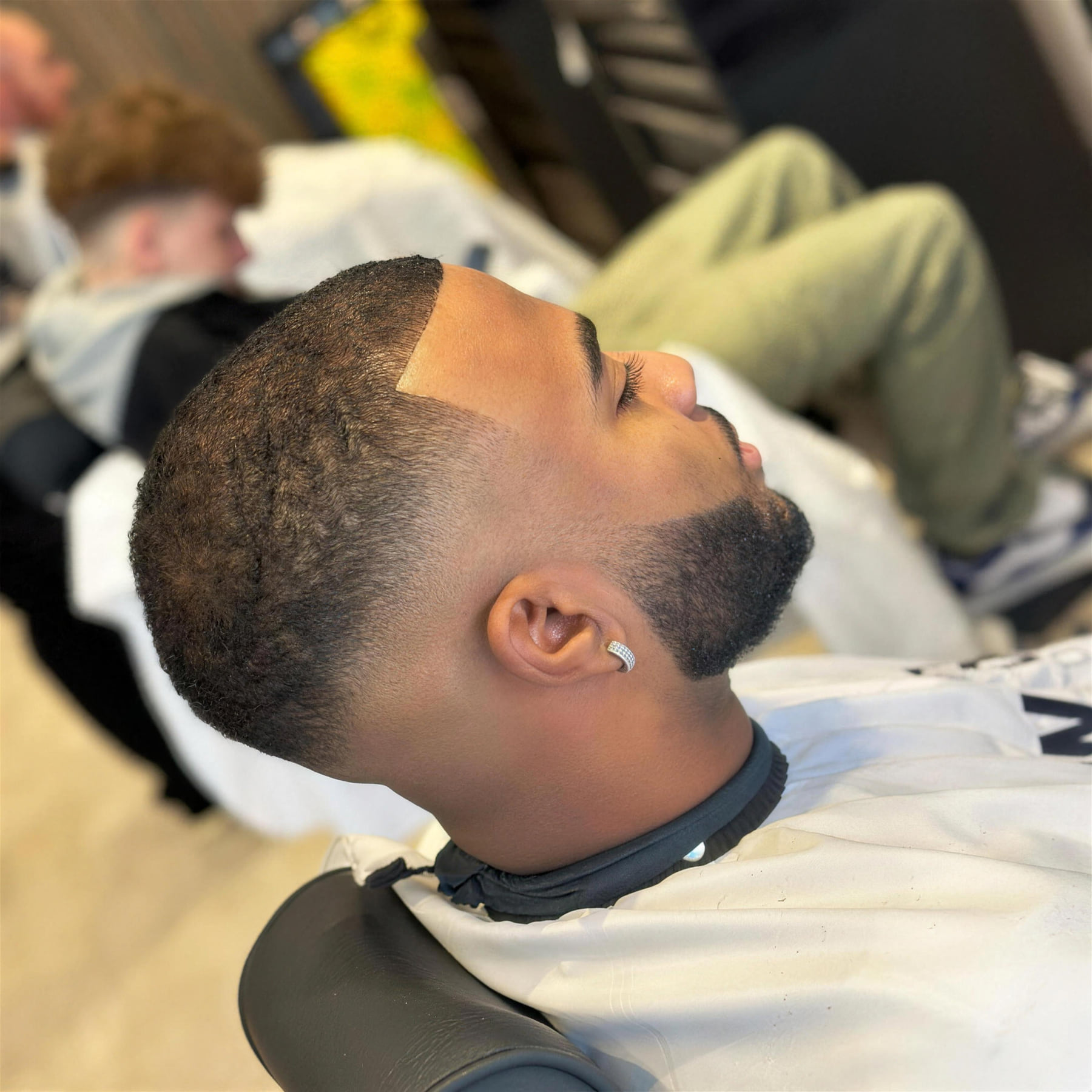 A fade with a sharp line-up, seen from the side at Benny's